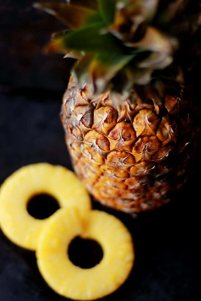 brown pineapple fruit beside slice fruits